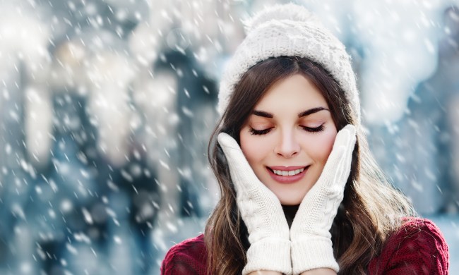 Closeup of woman in winter snowstorm with hands on face