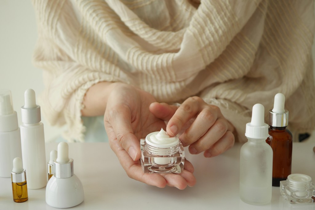 woman's hands holding skincare product