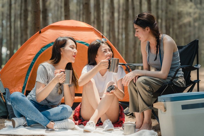 Three women camp outside of a tent