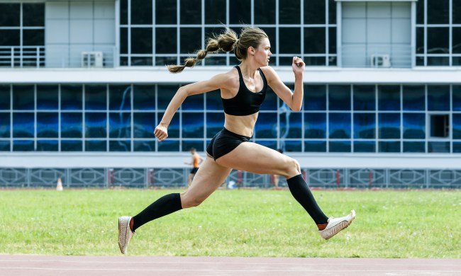 An action shot of a woman running while wearing compression stockings