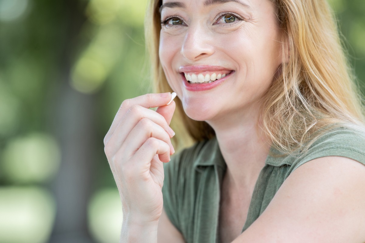  Woman holding vitamin smiles 